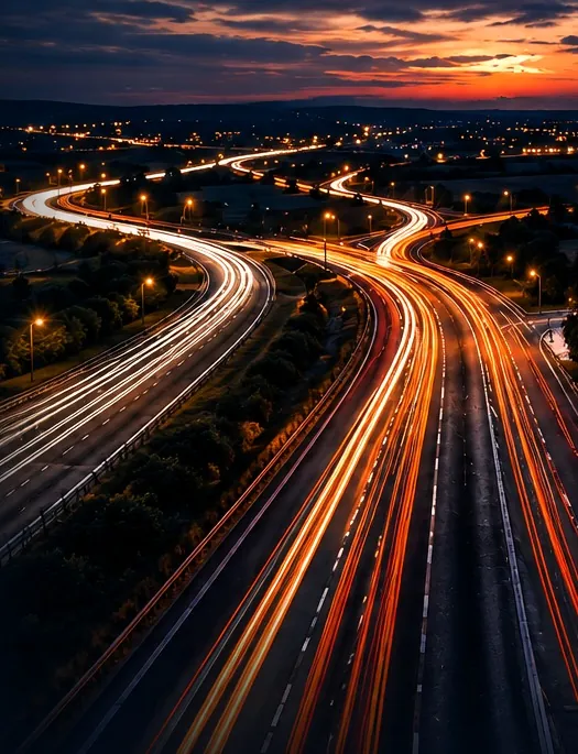 Motorway network at dusk with long-exposure light trails representing fast nationwide courier transport