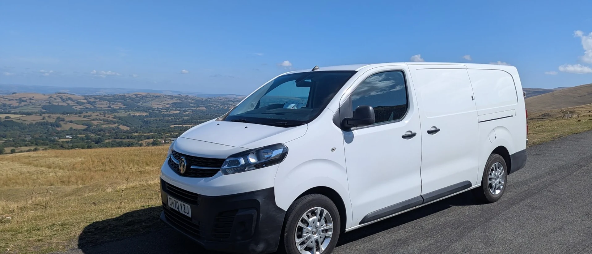 White Cranleigh Couriers Vauxhall Vivaro van on a countryside road